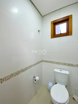 Foto de um banheiro com revestimento cerâmico nas paredes.