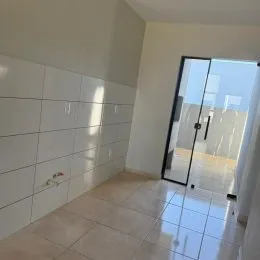 Hall de entrada com piso de cerâmica e paredes brancas.