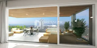 Sala de estar com vista para o mar através de portas de vidro.