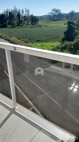 Vista de campos agrícolas e vegetação ao longo de uma estrada.