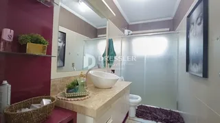 Foto de um banheiro com bancada e box de chuveiro.