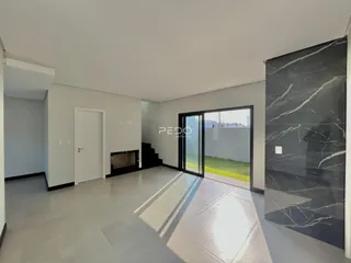Sala de estar com piso claro e parede de mármore escura.