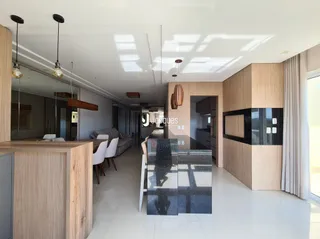 Sala de estar moderna com piso claro e painéis de madeira.