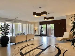 Sala de estar moderna com piso de cerâmica e grandes janelas.