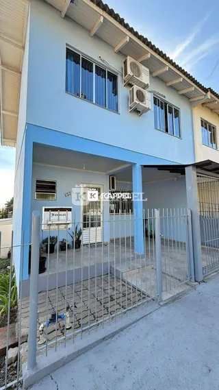 Fachada azul de uma casa em Lajeado, Brasil, com grade de segurança na frente.