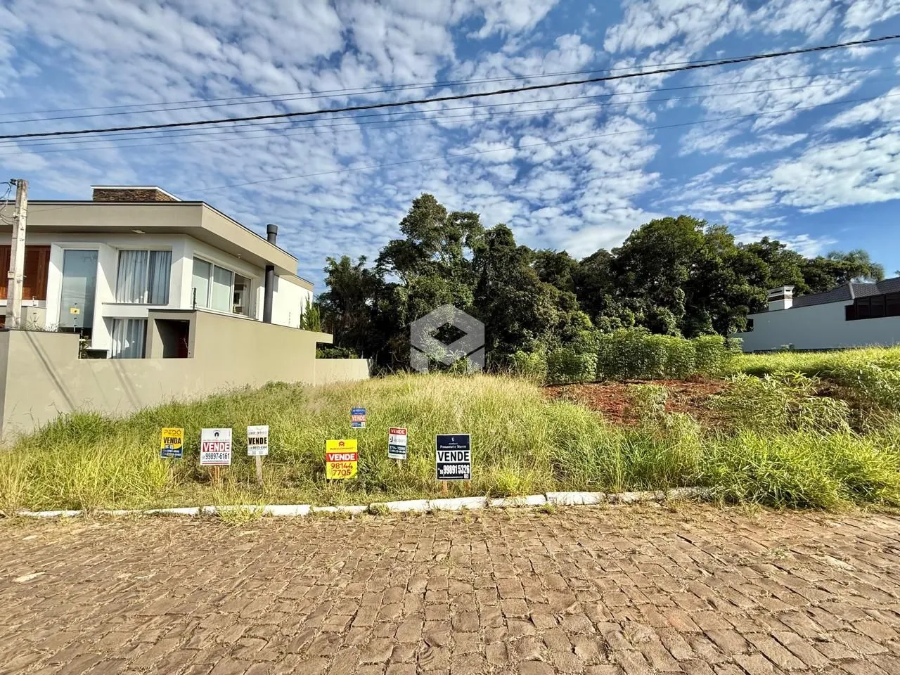 Vista externa de uma residência em Lajeado, Brasil, com vegetação no jardim.