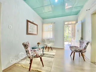 Sala de estar com paredes brancas e piso de madeira clara.