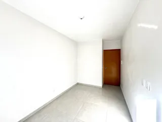 Corredor interno com paredes brancas e piso de cerâmica.