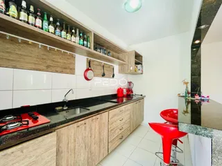 Cozinha moderna com armários de madeira e bancada escura.