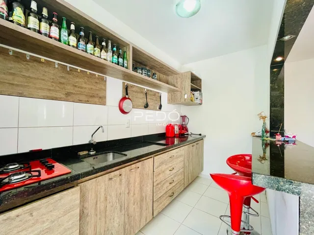 Cozinha moderna com armários de madeira e bancada escura.