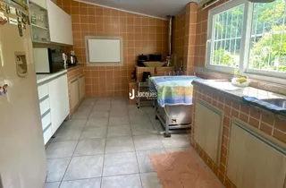 Cozinha com piso de cerâmica e armários brancos.