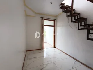 Hall de entrada com piso de mármore claro e paredes brancas.