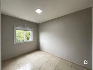 Ambiente interno de uma sala com piso de cerâmica clara e janela.
