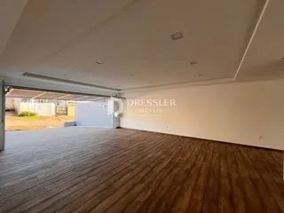 Sala de estar com piso de madeira e acesso a uma área externa coberta.