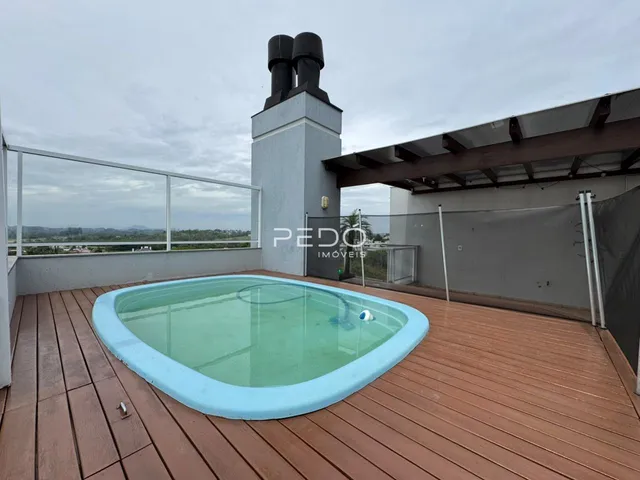 Vista de uma piscina e deck de madeira em uma propriedade em Lajeado.