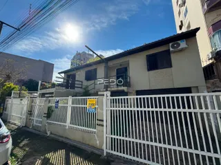 Fachada de uma residência em Lajeado, Brasil, com cerca branca na frente.