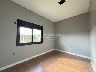 Ambiente interno com piso de madeira e janela.