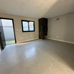 Sala ampla com piso claro e paredes neutras.