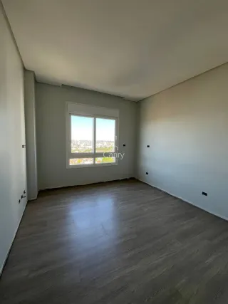 Sala de estar com piso de madeira e vista para a paisagem urbana.