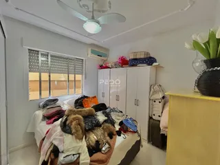 Quarto interno com cama e guarda-roupa branco.