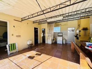 Foto de uma área interna com piso de cerâmica e estrutura de teto exposta.