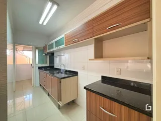 Cozinha com armários de madeira e piso claro.