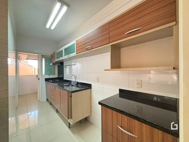 Cozinha com armários de madeira e piso claro.