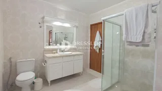 A foto mostra o interior de um banheiro com vaso sanitário e box de vidro.