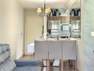 Sala de estar com mesa de jantar e cozinha moderna em um apartamento.