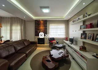 Sala de estar ampla com sofá de couro e lareira em ambiente moderno.