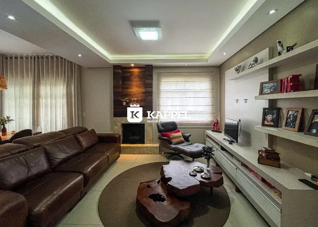 Sala de estar ampla com sofá de couro e lareira em ambiente moderno.