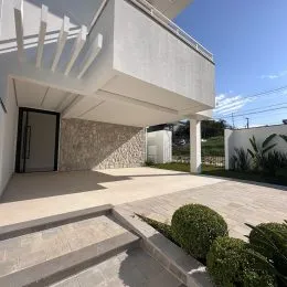 Foto da fachada de uma residência em Lajeado, Brasil, mostrando uma área externa com piso de concreto.