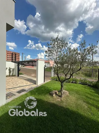 Vista externa da propriedade com jardim e cerca.