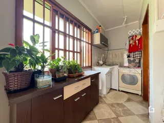 Vista de uma sala com grandes janelas e móveis de madeira.