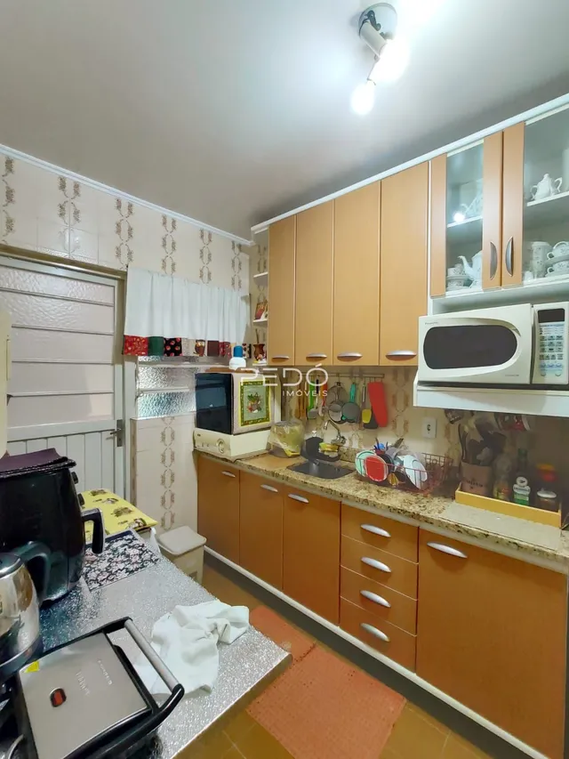 Foto de uma cozinha com armários de madeira e bancada clara.