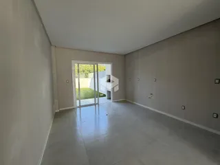 Uma sala de estar ampla com piso de concreto e portas de vidro.
