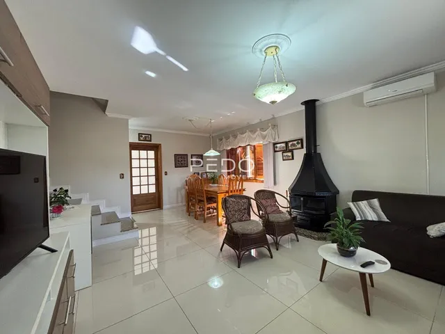Sala de estar com piso claro e lareira no interior da residência.