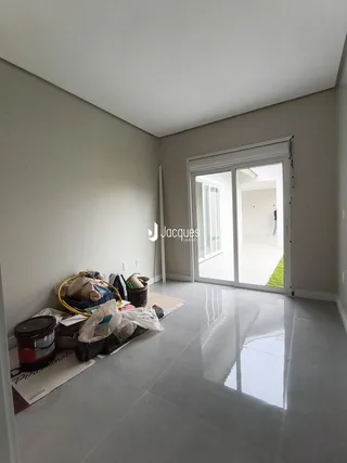 Ambiente interno de uma sala com piso brilhante e porta de vidro.