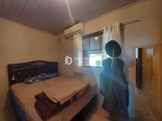 Quarto com cama e janela em ambiente interno.