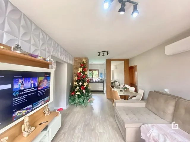 Interior de uma sala de estar com decoração de madeira e televisão.