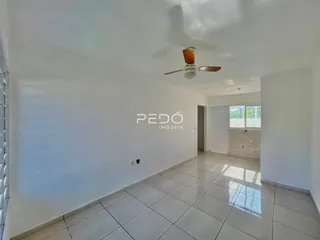 Interior de uma sala com piso de cerâmica e paredes brancas.