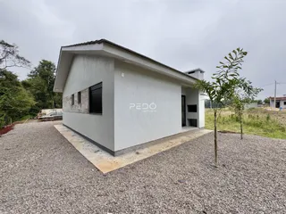 Fachada externa de uma residência em Lajeado, Brasil, com terreno de cascalho.