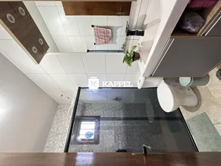 Foto de um ambiente interno com piso de cerâmica e revestimento de parede branco.