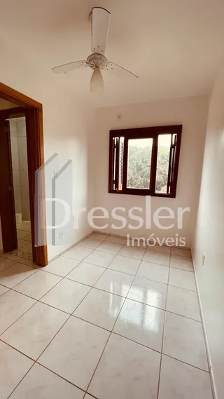 Ambiente interno de uma sala com piso de cerâmica clara.