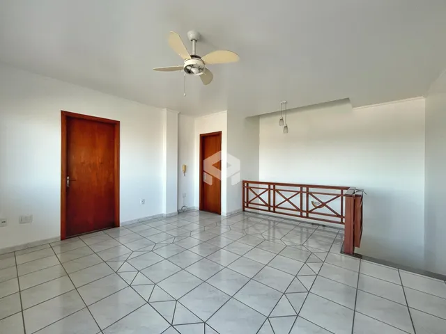 Ambiente interno de uma sala com piso de cerâmica e portas de madeira.