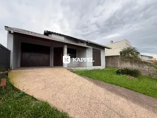 Fachada de uma casa com garagem e jardim em Lajeado.