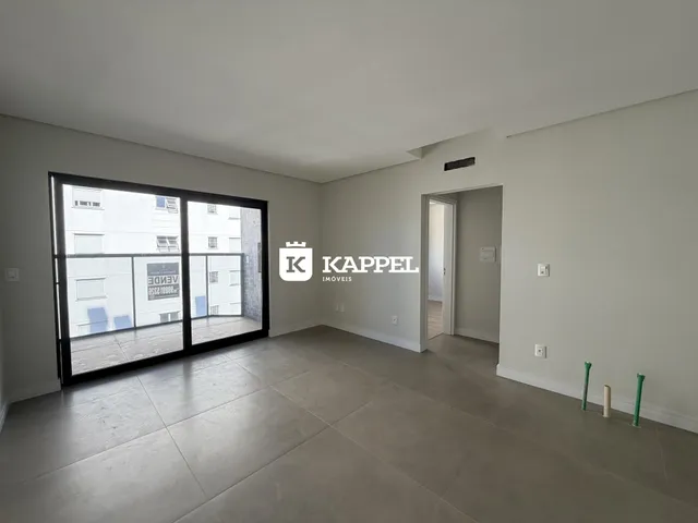 Sala de estar ampla com porta de vidro que dá para a área externa.
