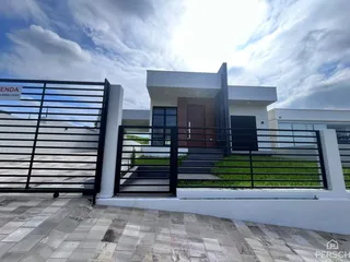 Fachada moderna de uma residência em Lajeado, Brasil, com portão preto e paisagismo.