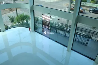 Vista interna de um ambiente com piso reflexivo e estrutura de sacada.
