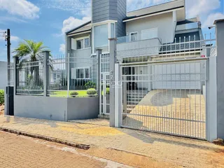 Fachada de uma residência com portão de ferro e cerca em Lajeado, Brasil.